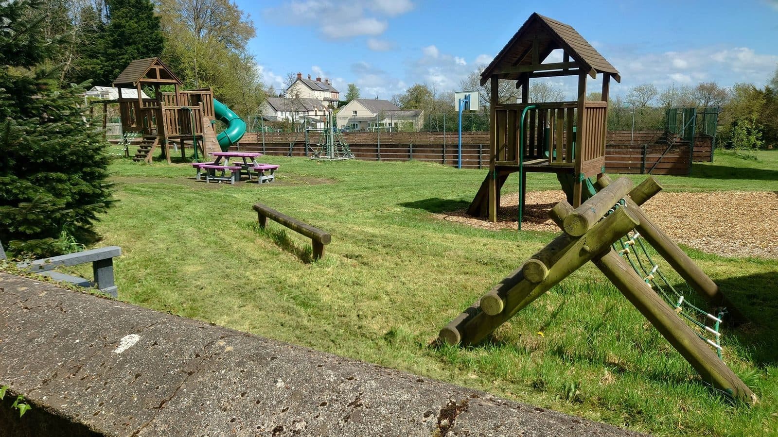 Community play park with mowed grass and well-maintained grounds